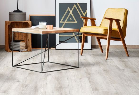 modern flat with a grey leather sofa, grey laminate flooring and a rug